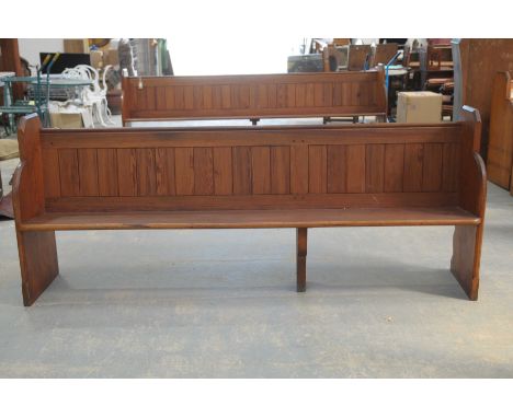 A Victorian pitch pine church pewRaised on two shaped end bracket supports and fitted with a rear rail book trough, 227cm lon