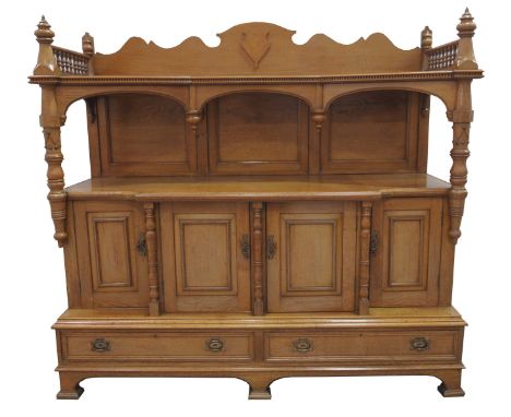 An early 20th Century honey oak buffet sideboard The super structure back with a shaped pediment  flanked by turned spindle g