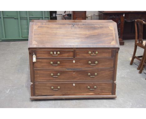 A George III mahogany bureau The fall front inlaid with fan detail enclosing a compartmentalised interior over four graduated