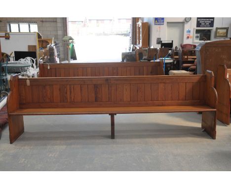 A Victorian pitch pine church pewRaised on two shaped end bracket supports and fitted with a rear rail book trough, 227cm lon