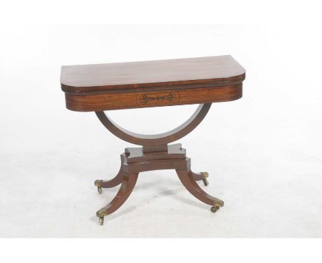 A Regency mahogany folding card tableThe rectangular top with rounded front corners ebonised stringing enclosing a baize line