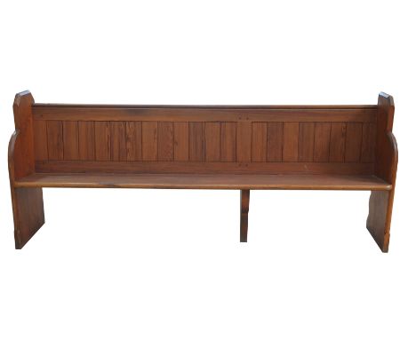A Victorian pitch pine church pewRaised on two shaped end bracket supports and fitted with a rear rail book trough, 227cm lon