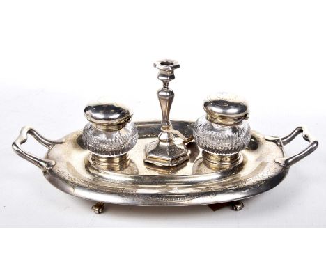 A Victorian silver inkstandOf oval form with engraved scroll detail and two handles, centering two circular receivers with cu