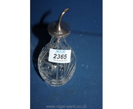 A cut glass oil Bottle with silver top.