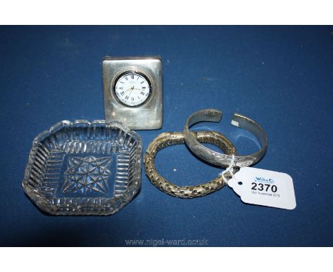 A silver Clock and two oriental silver Bracelets.