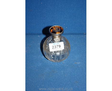 A hallmarked 1918 silver perfume bottle featuring tortoiseshell lid with silver inlay and cut glass body and glass stopper.