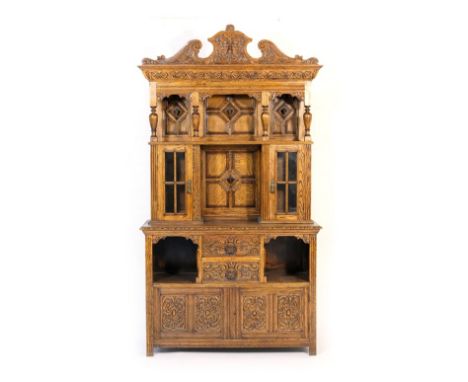 Flemish carved oak salon cabinet, the pediment centred with a carved Green Man mask over an open moulded panel back with a ce