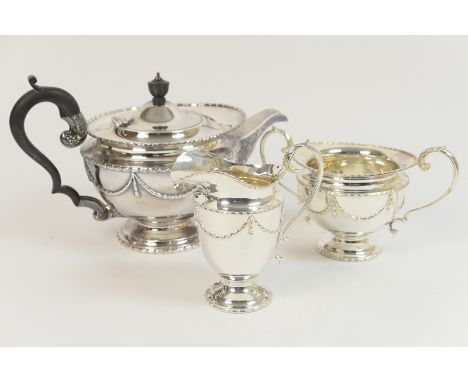 Late Victorian silver three piece tea service in the Adam style, Birmingham 1895, comprising lidded teapot, milk jug and suga