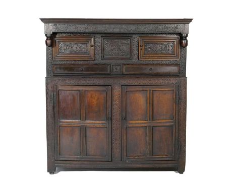 Oak joined press cupboard, dated 1691, with later restorations, having a later ogee moulded cornice over a frieze carved and 