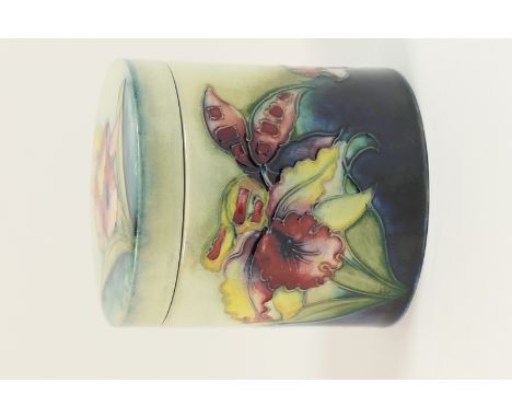 William Moorcroft Iris jar and cover, cylinder form decorated with flowers in flambe yellow and orange against a blue and sha