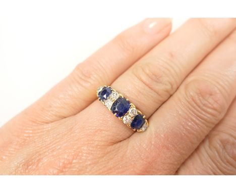 Sapphire and diamond cluster ring set with three oval sapphires, the largest approx. 5mm x 4mm, dispersed with six old brilli