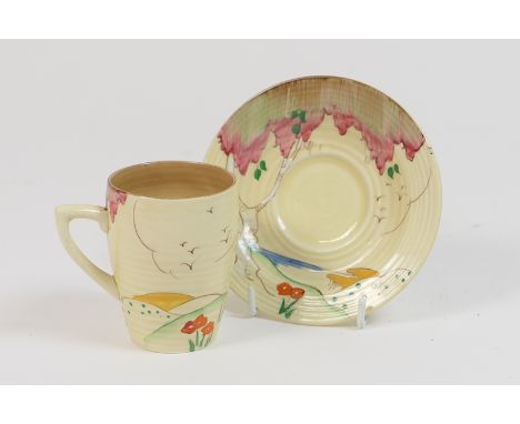 Clarice Cliff Wilkinson cup and saucer, decorated with a coastal landscape in colours against a honey glaze