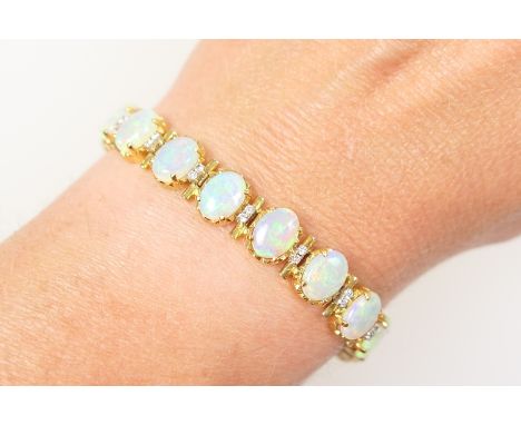 Attractive opal and diamond line bracelet, having 19 well matched cabochon opals, each of approx. 8mm x 6mm, each separated b