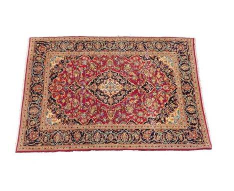 Najafabad woollen carpet, the red field centred with a black and fawn medallion and dispersed with palmettes and with a black