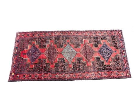 Large Turkman carpet, having a central crenellated red field dispersed with lozenge shaped reserves in colour against a black