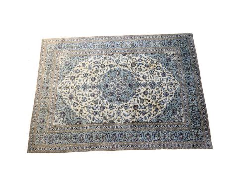 Kashan woollen carpet, fawn field with a central sage green palmette medallion, similar spandrels and a sage green palmette b
