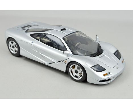 AN UNBOXED PAULS MODEL ART DIECAST 1/12 SCALE MCLAREN F1 SPORTS CAR, door window one side is loose and also missing filler ca