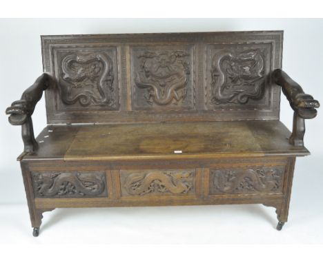 A late 19th/early 20th century Chinese style mahogany monks bench, highly decorated throughout with carved dragon motifs, rai