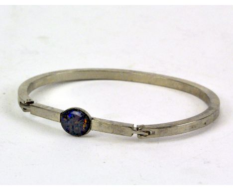 An unmarked white metal snap bangle set with synthetic opal, 14.9g