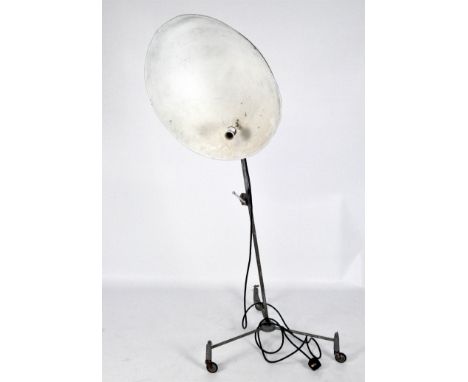 A vintage tripod based lamp with large aluminum shade, raised upon castors, 148cm high