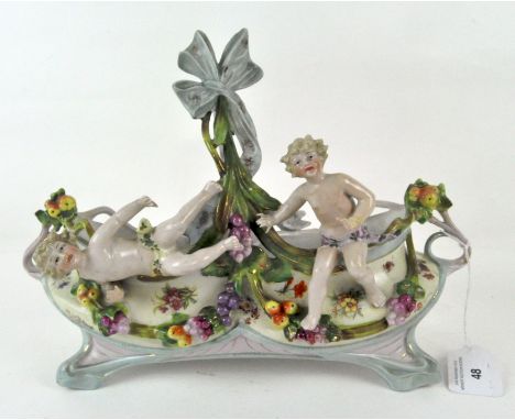 A French ceramic planter, modelled as two putti surrounded by fruit and gilt scrolls, height 23cm