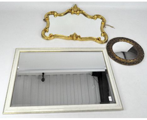 Three wall mirrors, two contemporary examples, one with a white frame and bevelled edge, 99cm x 70cm, the other with a scroll
