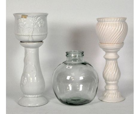 Two white ceramic jardiniere stands and a glass carboy, height 37cm
