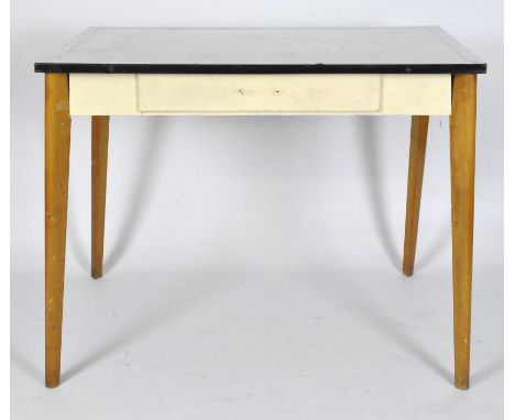 A mid-century enamel topped table, white enamel with black border, raised on splayed tapering legs, 74cm x 92cm x 54cm