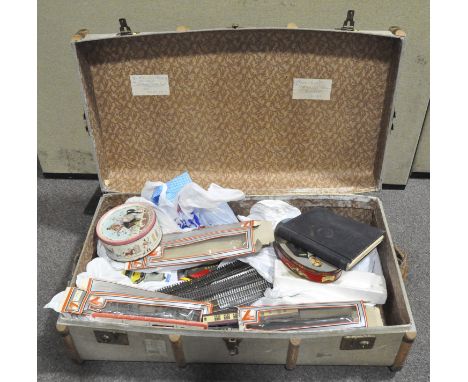 A large canvas and wood trim trunk containing Lima trains and tracks and collectables including a Queen Elizabeth II coronati