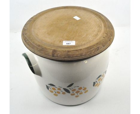 A glazed ceramic bread crock with round board, decorated with fruit amongst foliage, 30cm high