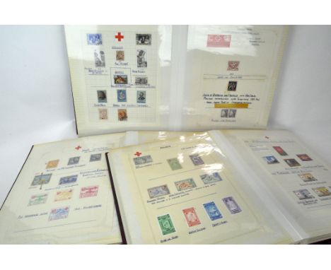 A collection of World Red Cross themed stamps and First Day Covers, contained in three albums