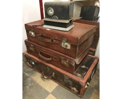 Three vintage suitcases and a time recorder machine 
