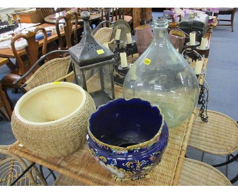 An early 20th century painted planter and another, a contemporary garden storm lantern, a green glass carboy and a wicker dri