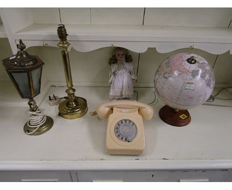 A CRAM classic globe, a collectors doll on stand, a vintage cream cased dial telephone and two table lamps