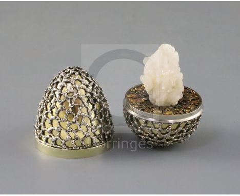 A late 1960's parcel silver gilt 'surprise' egg by Stuart Devlin, with stylised cagework decoration, opening to reveal a quar