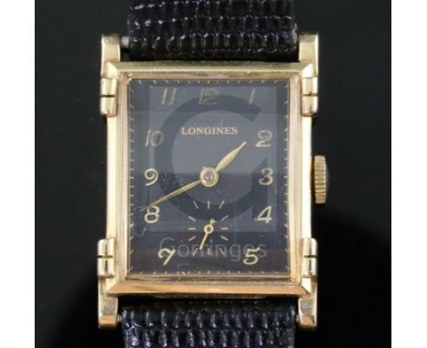 A gentlemans stylish 1930's 14k gold Longines manual wind wrist watch, with raised lugs and rectangular black Arabic dial wit