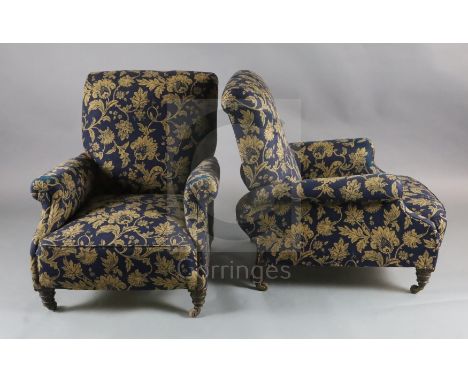 A pair of Victorian club armchairs, with blue floral scroll upholstery, on turned mahogany legs fitted ceramic castors, W.2ft