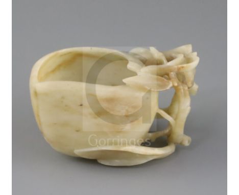 A Chinese jade 'peach' cup, probably 17th / 18th century, the creamy coloured stone with some brown inclusions carved as peac