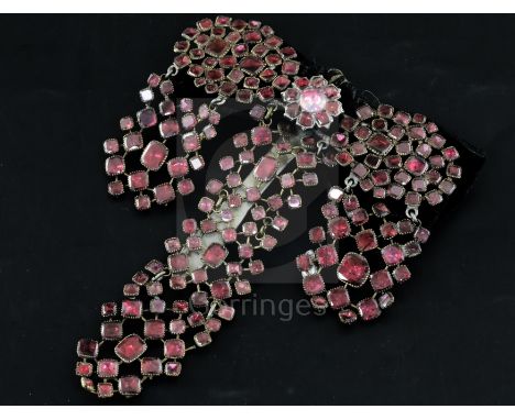 A late 18th century French pinchbeck and shaped cut garnet set drop hair ornament, with black ribbon sash and silver clip, 10