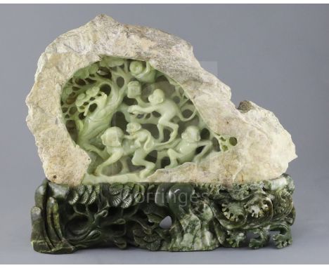 A Chinese bowenite jade boulder carving of monkeys clambering through a pine tree, 20th century, on a spinach green bowenite 