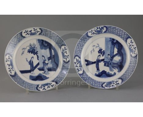 A pair of Chinese blue and white 'ladies' plates, Kangxi period, each painted with two ladies in a pavilion garden setting wi