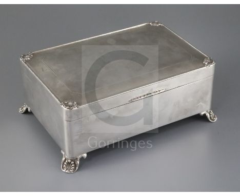 A George V Art Deco silver rectangular cigar box, by C.s. Green &amp; Co, the engine turned lid with shell corners, on four s
