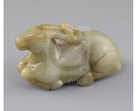 A Chinese pale celadon and russet jade figure of a recumbent stag, 19th century, L.8.7cm