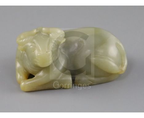 A Chinese celadon and russet jade figure of a recumbent ox, late Qing dynasty, L.8cm