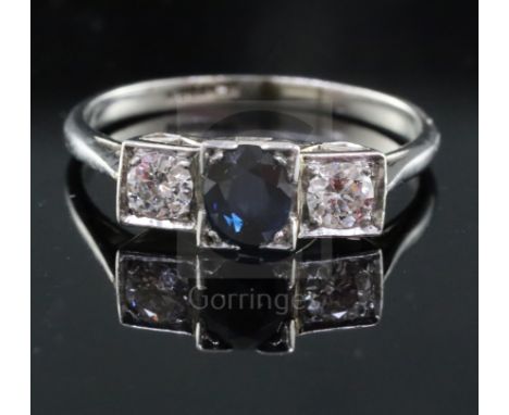 A 1930's platinum, sapphire and diamond three stone ring, with oval cut sapphire and round cut diamonds, size R.