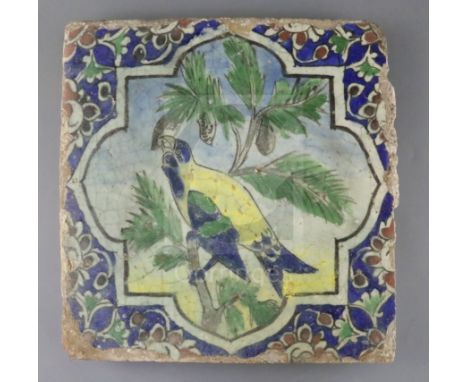 A large Persian 'parrot' tile, Qajar dynasty, painted in colours to a octafoil reserve within foliate borders, 29.5cm sq., gl