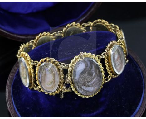 A cased Victorian gold and glazed plaited hair oval panel family memento bracelet, comprising nine glazed panels with plaited