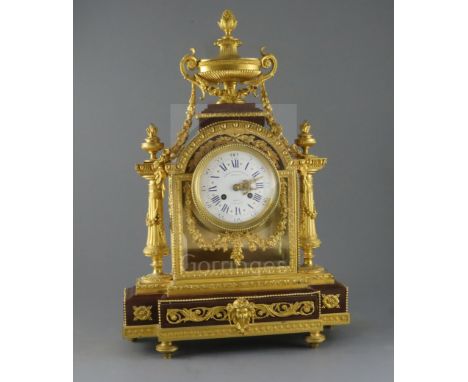 A 19th century French Louis XVI style ormolu and red marble mantel clock, the architectural case with urn and floral swag dec