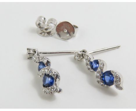 A pair of 18ct white gold sapphire and diamond twist drop earrings, with stud fittings, each earring with two sapphires and d