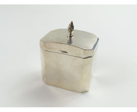 A silver tea caddy with hinged lid, made by Synyer & Beddoes in Birmingham 1922; the panels of octagonal form, and the lid fe